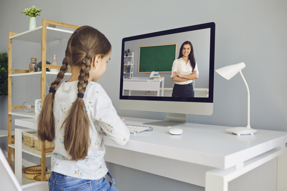 Child watching her teacher on a screen